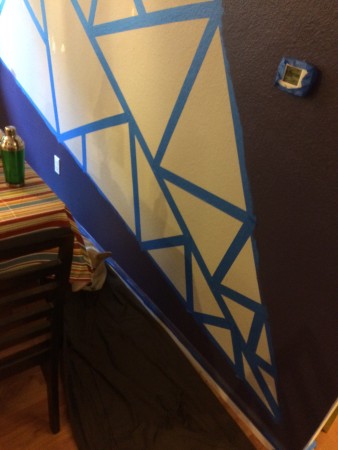 Dining room wall taped in triangular pattern in preparation for painting.